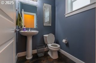 bathroom with toilet and baseboards