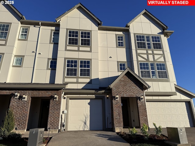 multi unit property with a garage, brick siding, and stucco siding