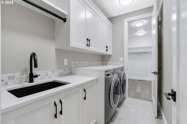 laundry room featuring cabinets, sink, and washing machine and clothes dryer