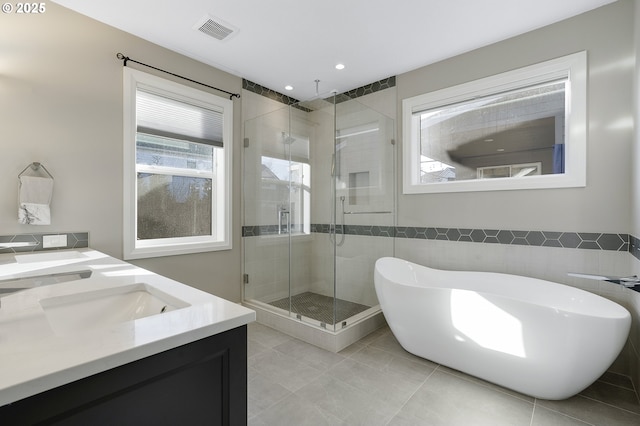 bathroom featuring tile walls, vanity, separate shower and tub, and tile patterned flooring