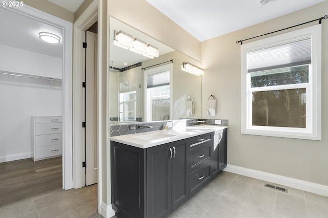 bathroom with tile patterned floors, a shower with shower door, and vanity