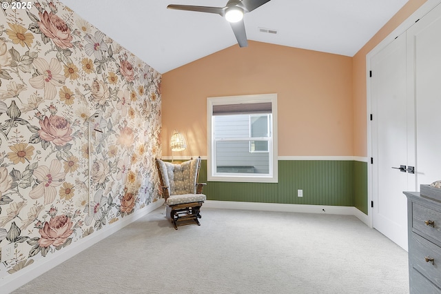 living area featuring vaulted ceiling, ceiling fan, and carpet flooring