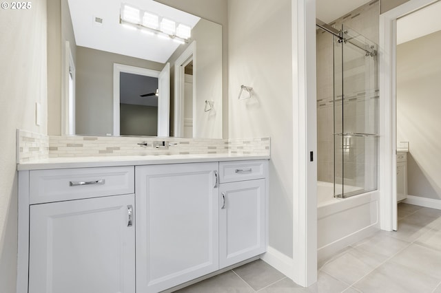 bathroom with combined bath / shower with glass door, vanity, tile patterned flooring, and tasteful backsplash