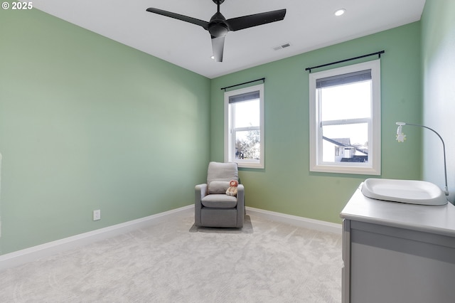 sitting room featuring ceiling fan and light colored carpet