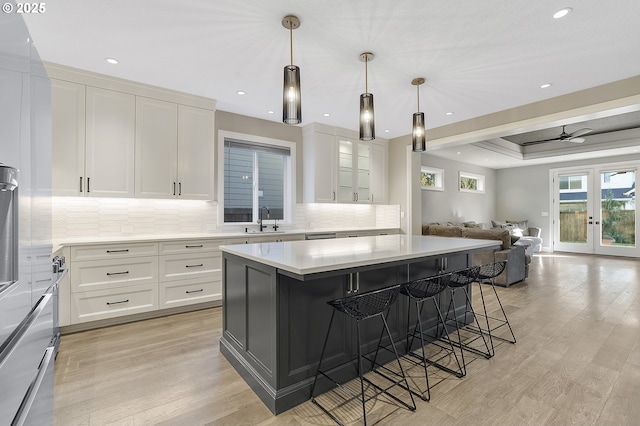 kitchen with light hardwood / wood-style flooring, a breakfast bar, white cabinetry, and a center island