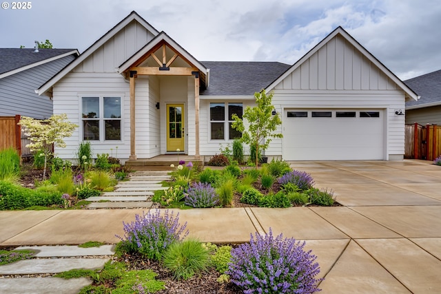 view of front of property with board and batten siding, an attached garage, fence, and a shingled roof