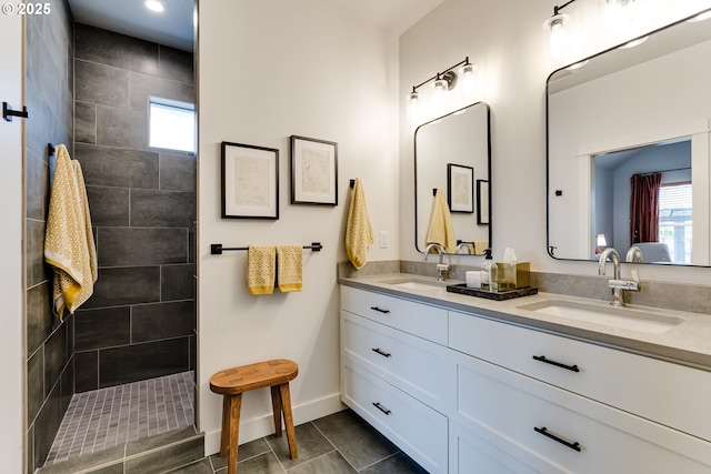 full bath with baseboards, a walk in shower, double vanity, tile patterned flooring, and recessed lighting