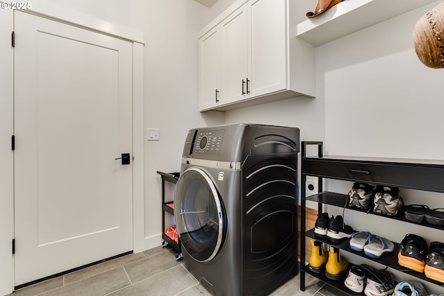 laundry area featuring cabinet space, light tile patterned floors, and washer / clothes dryer