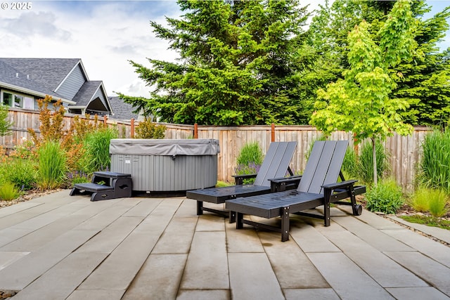 view of patio / terrace with a hot tub and a fenced backyard