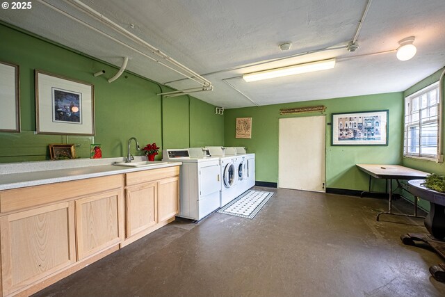 clothes washing area featuring cabinets, sink, independent washer and dryer, and a textured ceiling