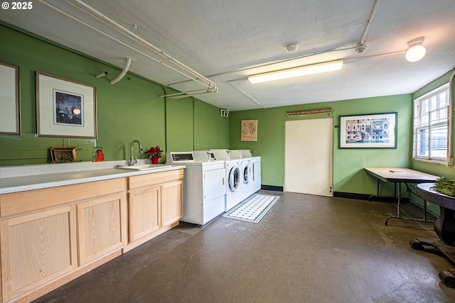 laundry area with cabinet space, a sink, and washing machine and clothes dryer