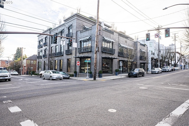 view of street with traffic lights, curbs, traffic signs, sidewalks, and street lights