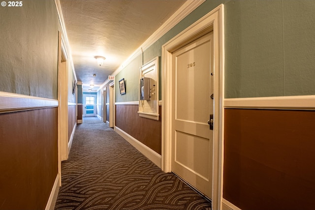 hall featuring carpet flooring, crown molding, and a textured ceiling