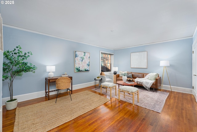 living area featuring ornamental molding, wood finished floors, and baseboards