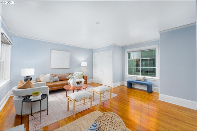 living room with baseboards, wood finished floors, and ornamental molding