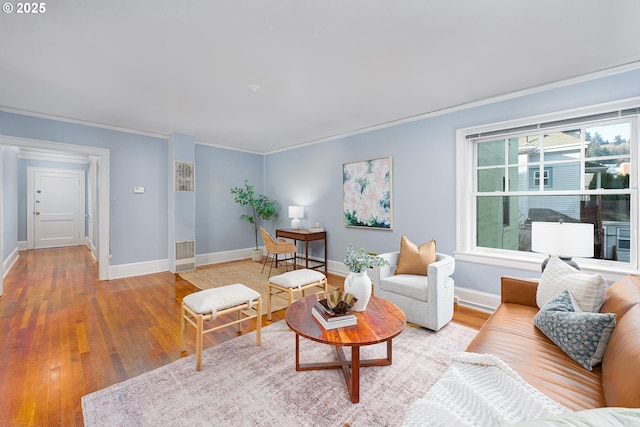 living room with hardwood / wood-style floors and crown molding