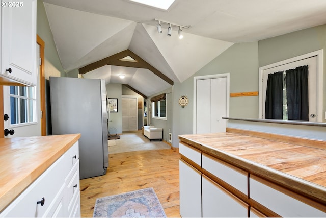 625 Wilson Rd, Mosier, OR 97040 - kitchen with wood counters, freestanding refrigerator, light wood-style floors, white cabinetry, and lofted ceiling