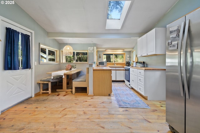 625 Wilson Rd, Mosier, OR 97040 - kitchen with white appliances, light wood finished floors, a skylight, white cabinets, and a peninsula