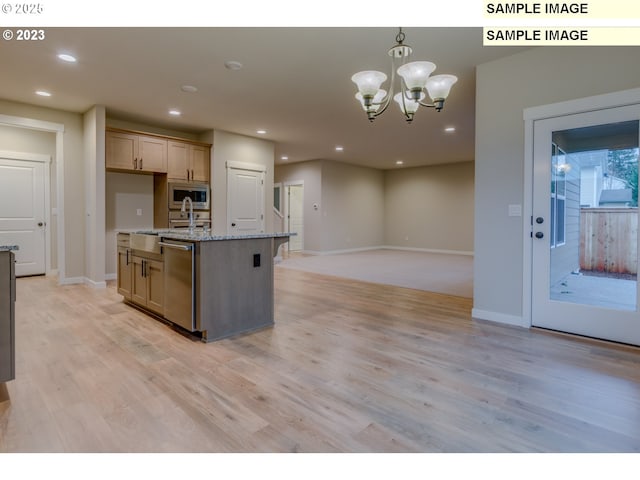 16513 SE Smith Rock St Unit 732, Happy Valley, OR 97086 - kitchen with stainless steel appliances, light wood finished floors, recessed lighting, light stone countertops, and a center island with sink