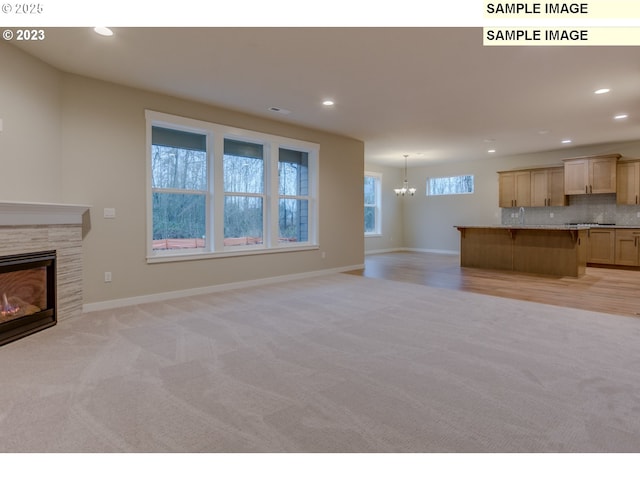 16513 SE Smith Rock St Unit 732, Happy Valley, OR 97086 - unfurnished living room with light colored carpet, a chandelier, a fireplace, recessed lighting, and baseboards
