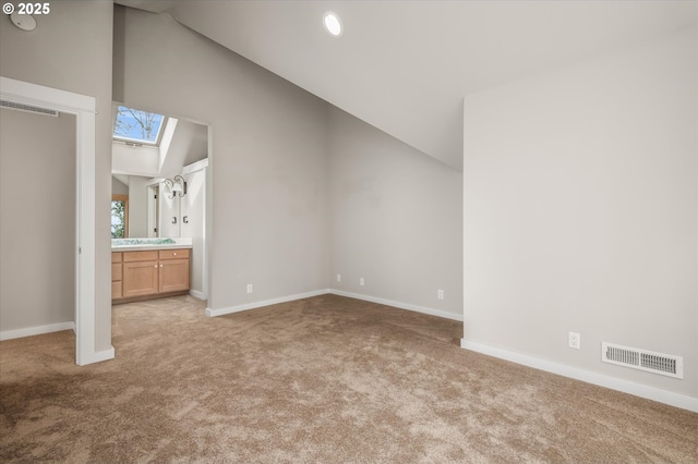 2405 Blacktail Dr, Eugene, OR 97405 - unfurnished bedroom with carpet, a skylight, baseboards, high vaulted ceiling, and connected bathroom