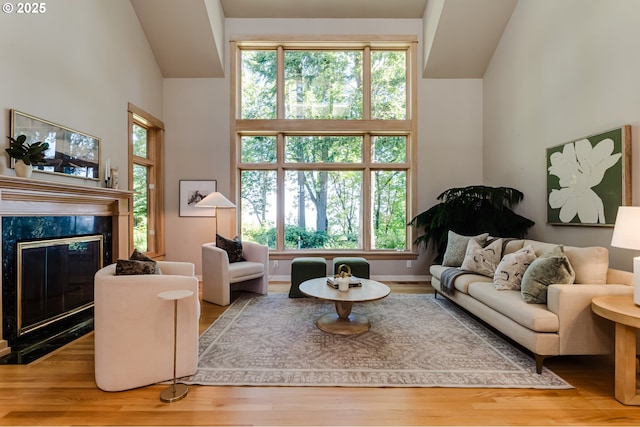 2405 Blacktail Dr, Eugene, OR 97405 - living area with a premium fireplace, wood finished floors, healthy amount of natural light, and a towering ceiling