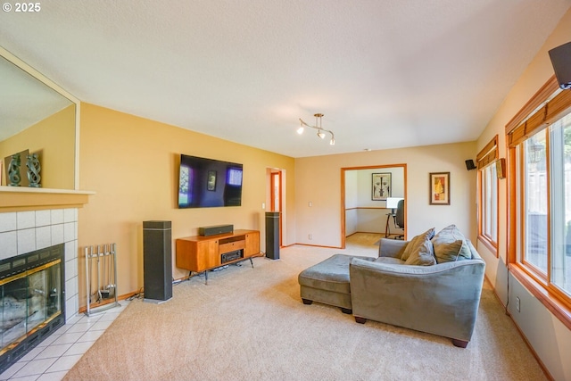 carpeted living area with a tile fireplace and baseboards