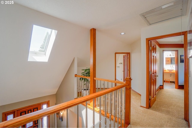 corridor with lofted ceiling with skylight, carpet flooring, an upstairs landing, and recessed lighting
