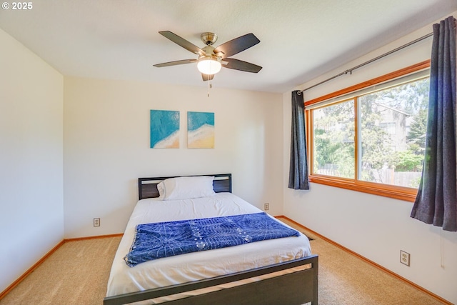 carpeted bedroom featuring baseboards and a ceiling fan