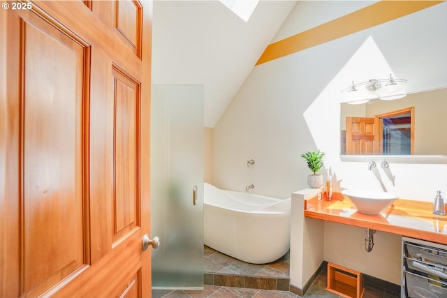 bathroom with a sink, a soaking tub, lofted ceiling with skylight, and tile patterned flooring