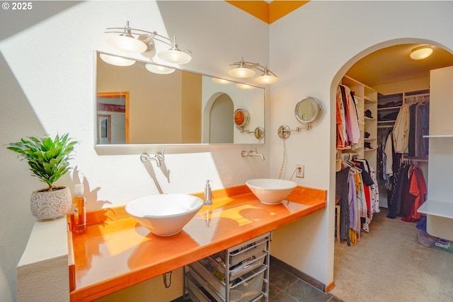 bathroom featuring a sink, double vanity, and a spacious closet