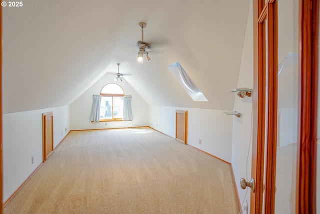 additional living space with lofted ceiling, light carpet, ceiling fan, and baseboards