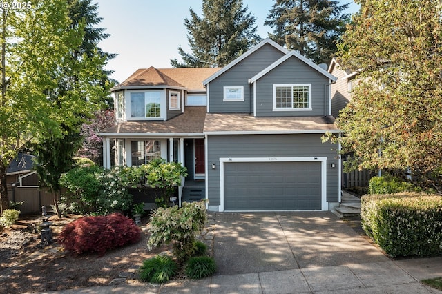 view of front of property with concrete driveway, an attached garage, fence, and roof with shingles