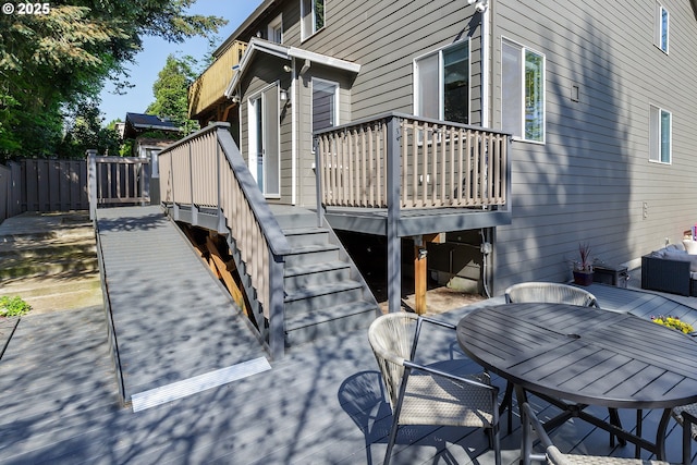 view of patio with a wooden deck, stairs, and outdoor dining space