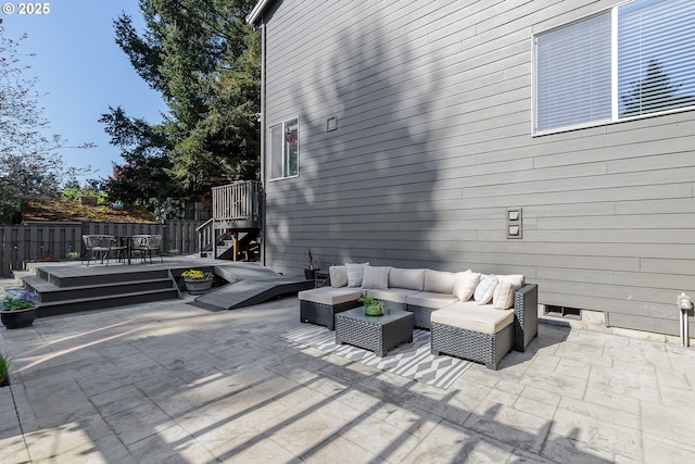view of patio with fence, a wooden deck, an outdoor hangout area, and outdoor dining space