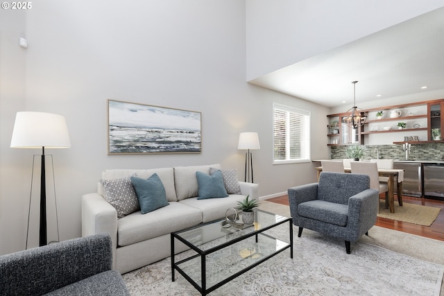living room with light wood-type flooring, recessed lighting, and a notable chandelier