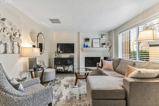 living room with a brick fireplace and hardwood / wood-style flooring