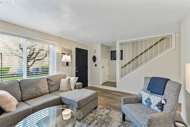 living room featuring wood-type flooring and a textured ceiling