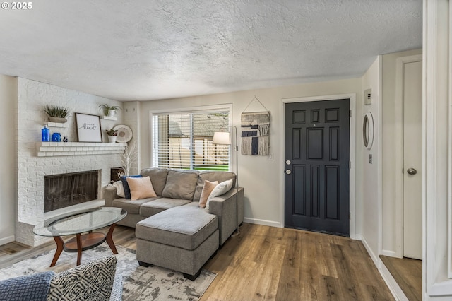 living room with hardwood / wood-style flooring, a textured ceiling, and a fireplace