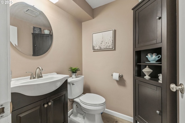 bathroom with hardwood / wood-style flooring, vanity, and toilet