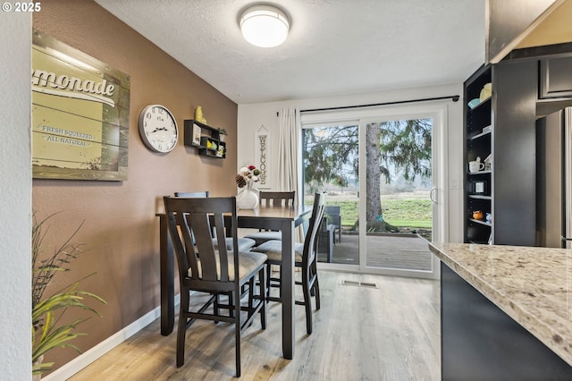 dining area with a textured ceiling and hardwood / wood-style floors