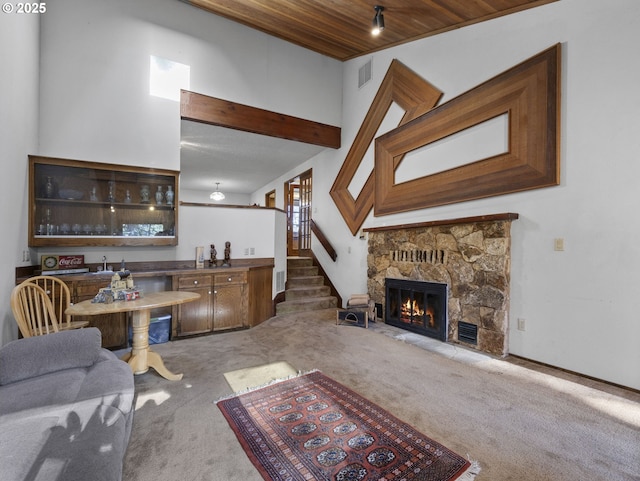 carpeted living room with bar, a fireplace, and wooden ceiling