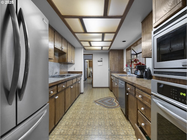 kitchen featuring appliances with stainless steel finishes, sink, and decorative backsplash