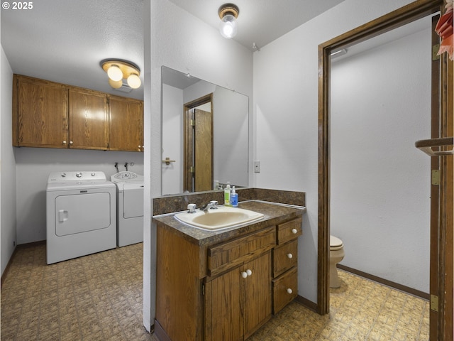 bathroom with vanity, washer and dryer, a textured ceiling, and toilet