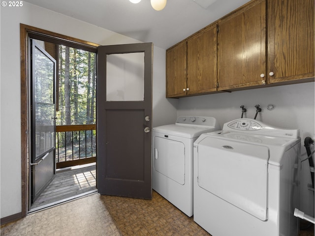 clothes washing area featuring cabinets and washing machine and dryer