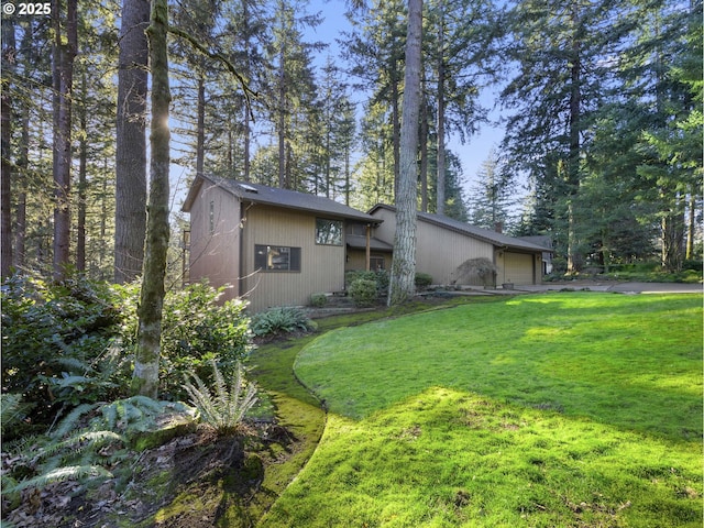 exterior space with a garage and a lawn