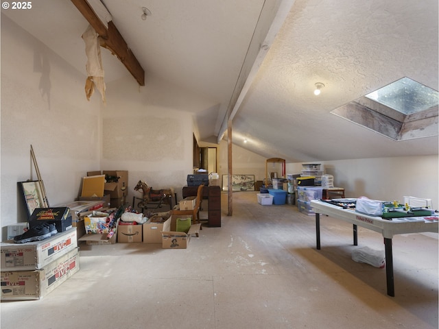 interior space featuring vaulted ceiling with skylight and a textured ceiling