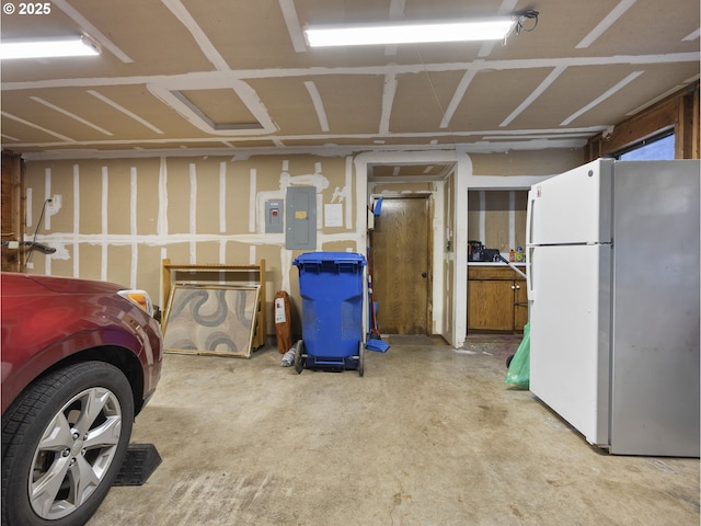 garage with white refrigerator and electric panel