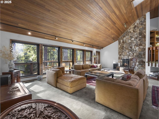 carpeted living room featuring wood ceiling, track lighting, a fireplace, and high vaulted ceiling