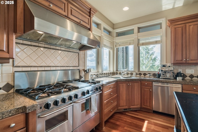 2640 NW Birkendene St, Portland, OR 97229 - kitchen featuring appliances with stainless steel finishes, range hood, healthy amount of natural light, tasteful backsplash, and recessed lighting